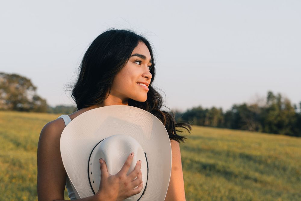 Portrait session in a field with soft lighting and natural scenery.