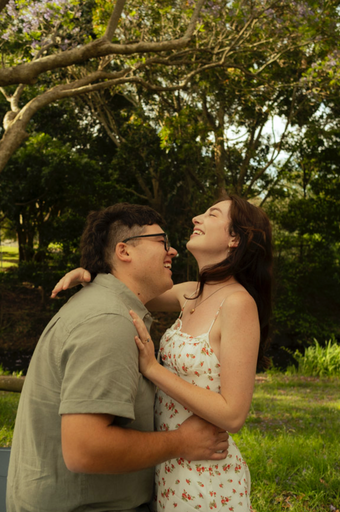 Couple sharing an intimate moment in a lush garden setting.