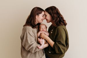 Intimate lifestyle photography series showing tender family moments against neutral backgrounds.