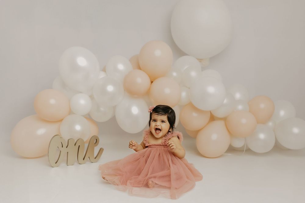 Maternity celebration setup with balloon garland and gold 'Mrs' sign.