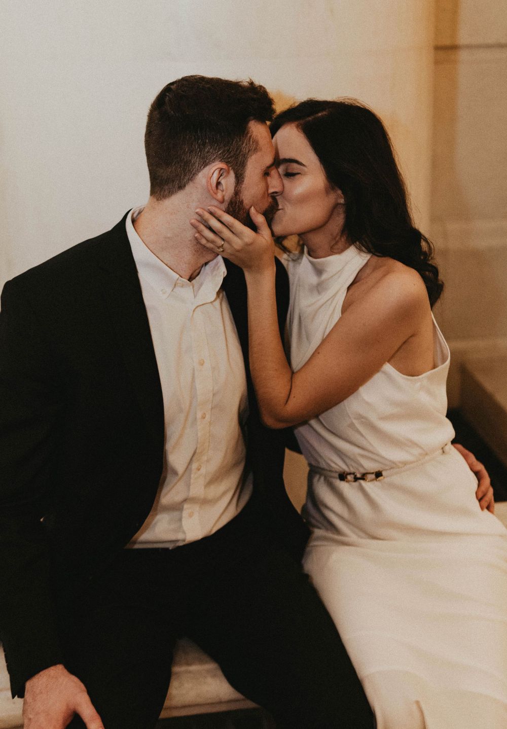 A romantic moment captured between a couple in formal attire.