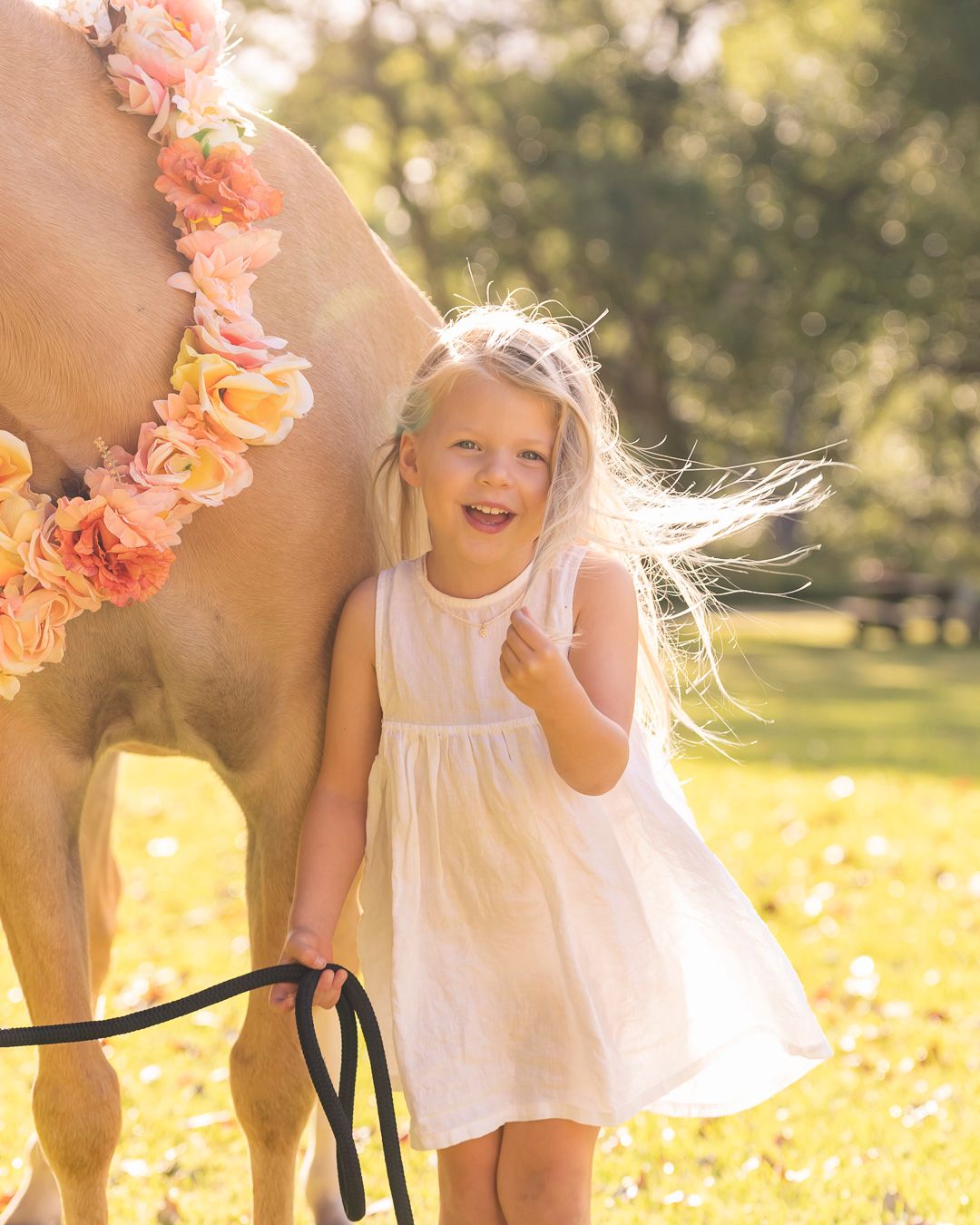 A series of dreamy photos showing interactions with a horse decorated with peach flowers.