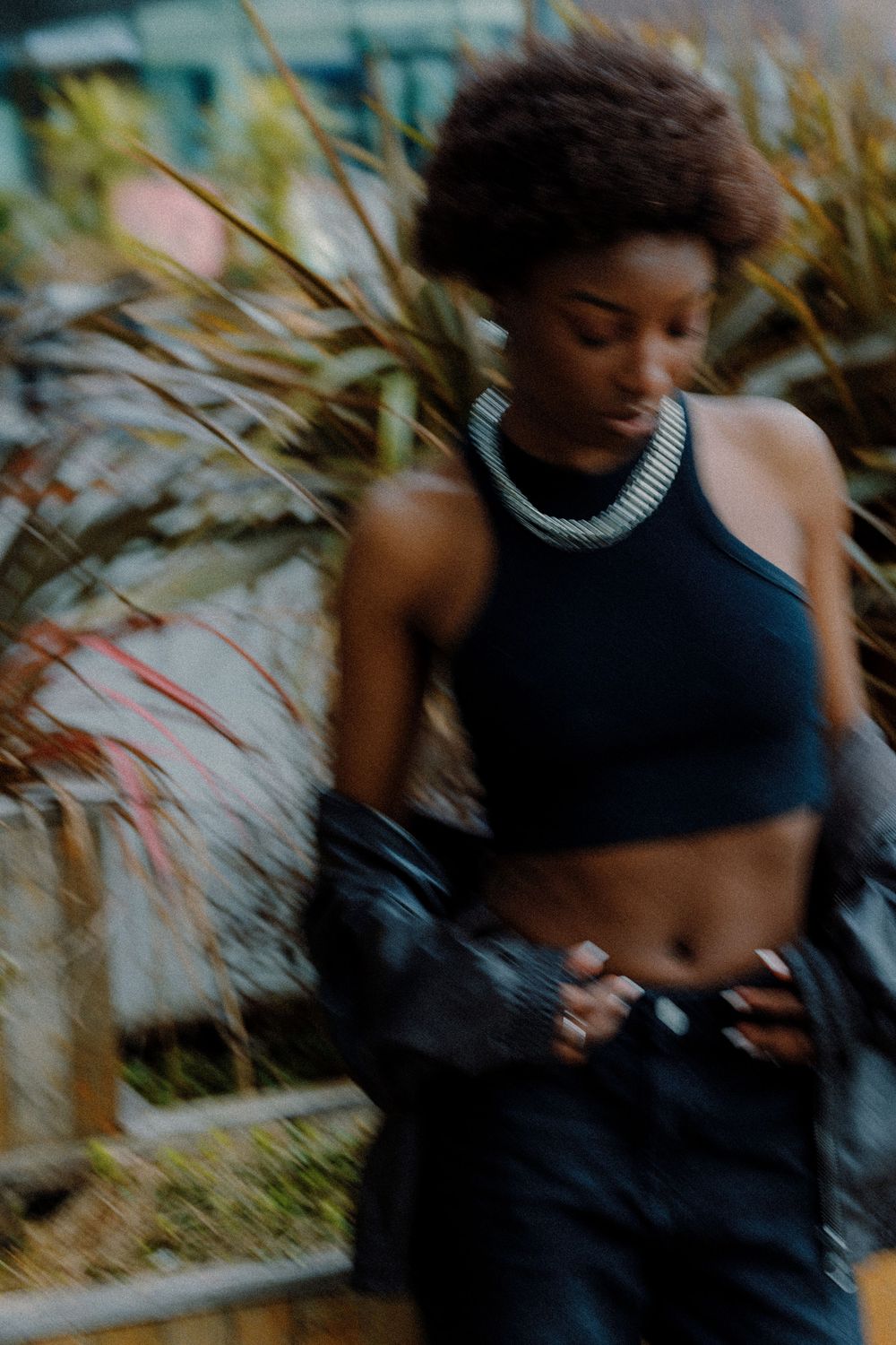 Dynamic fashion shoot in natural setting with model wearing black athletic wear.