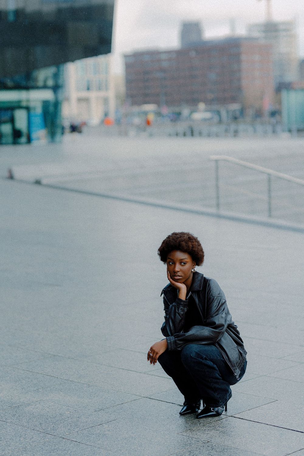 A sequence of five photos shows a figure in dark clothing crouching and moving low across an urban plaza.