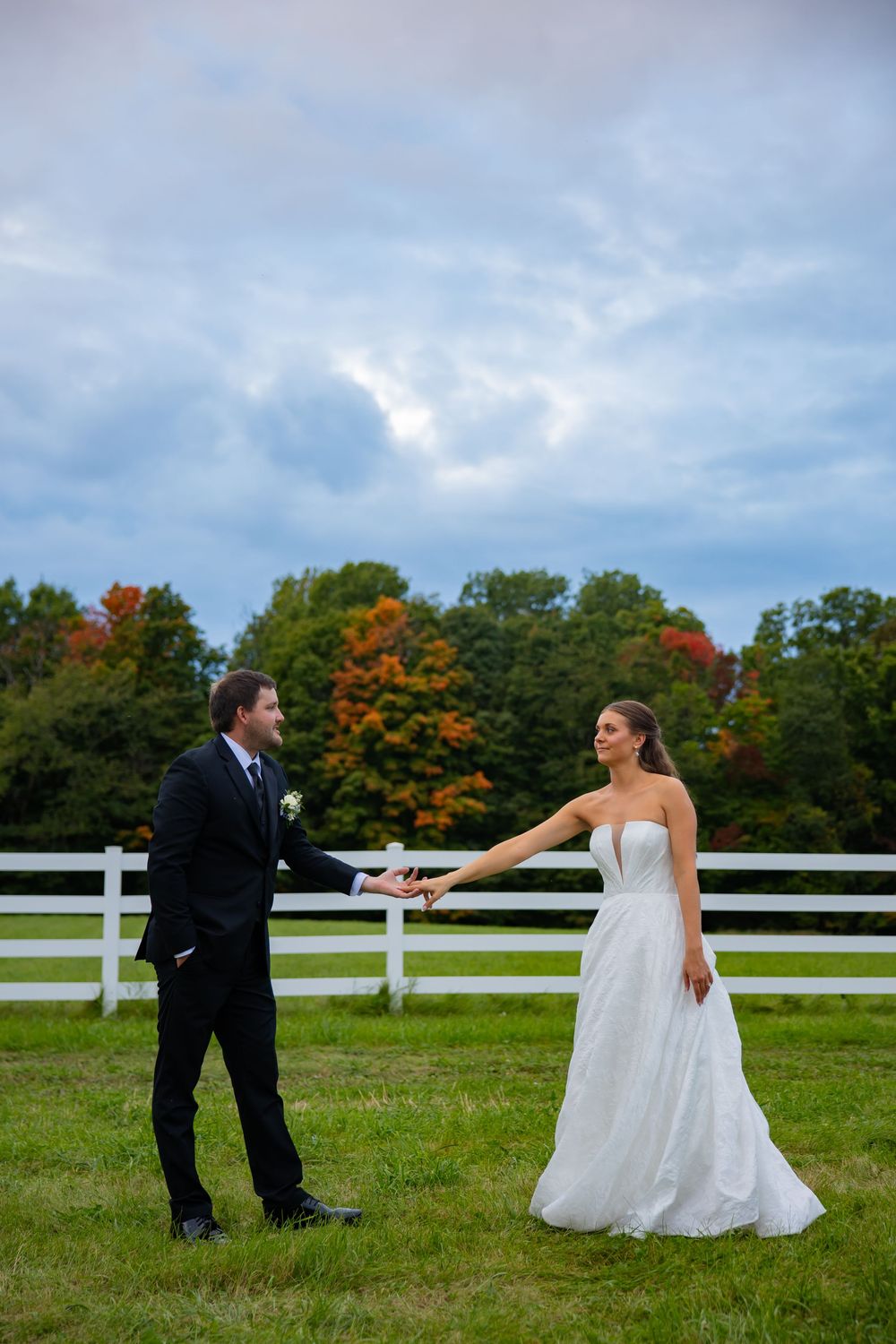 Bemidji couple holds hands with Bemidji fall colors behind