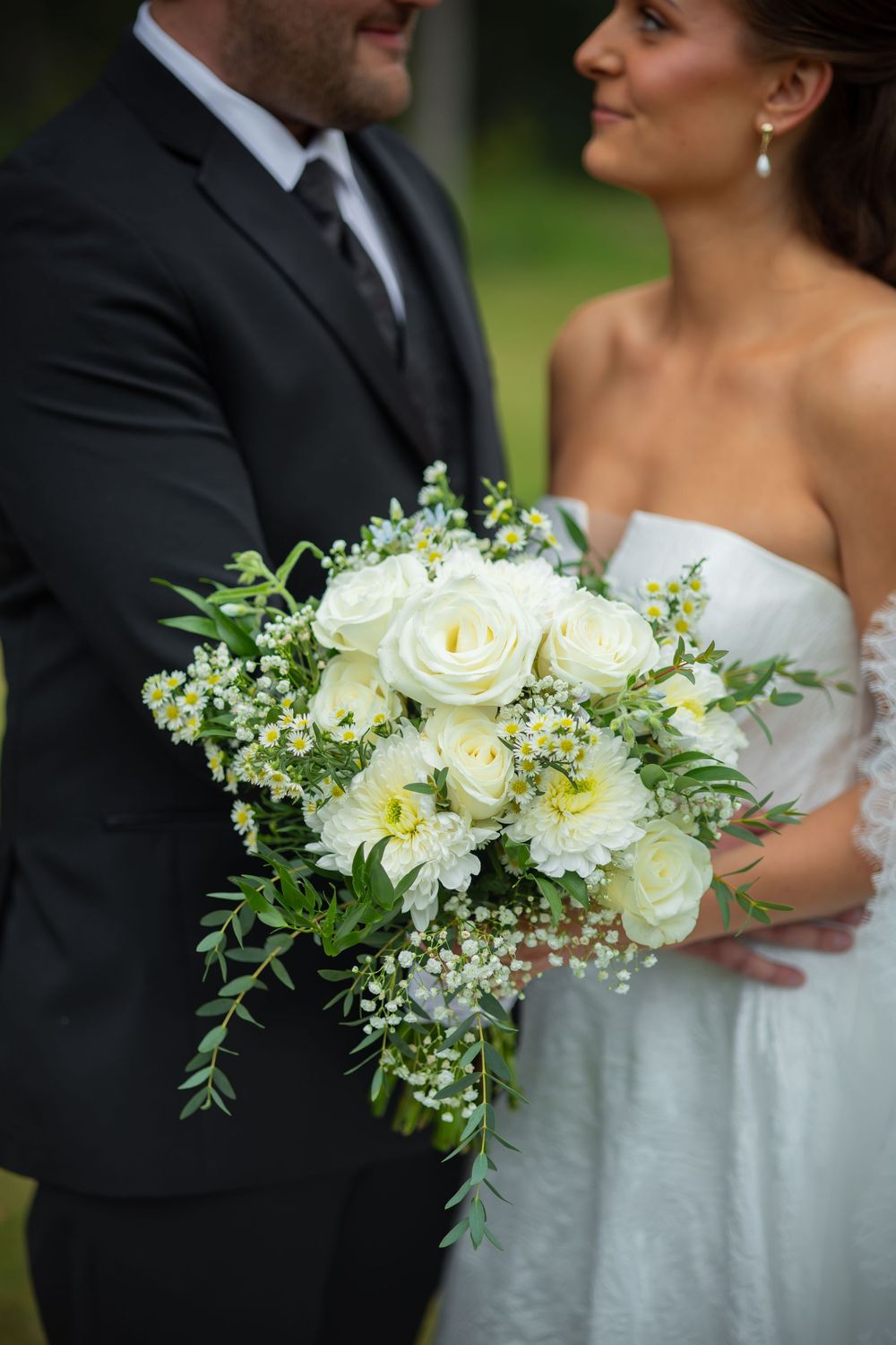 Florals are shown with wedding couple in background