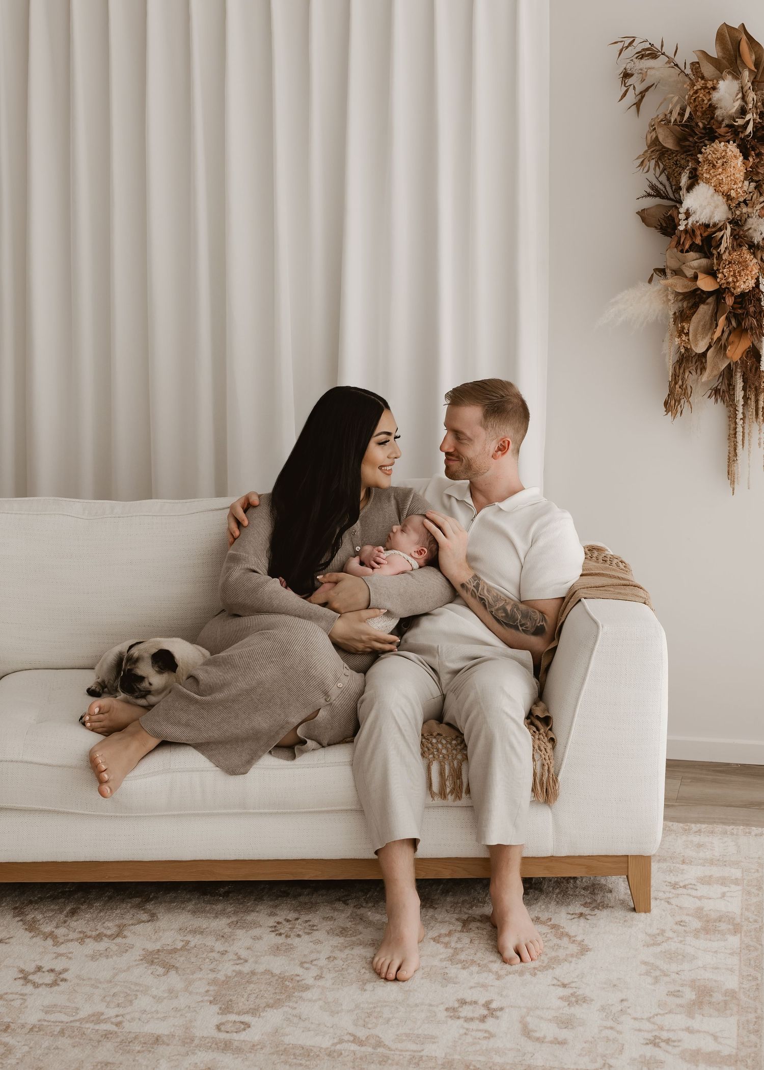 Intimate family moment with parents cradling young child in white room.