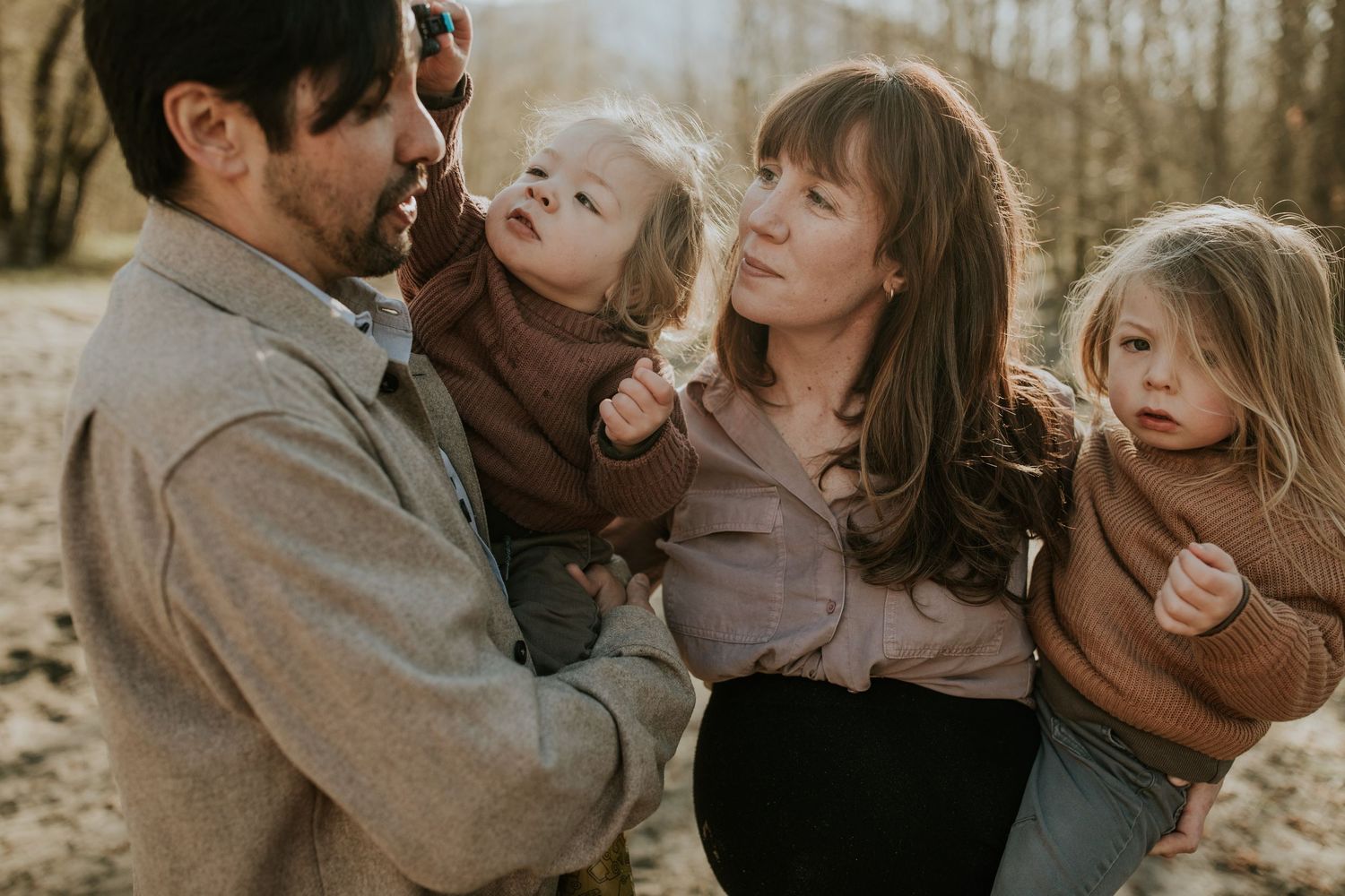A candid family portrait captured during golden hour in casual attire.