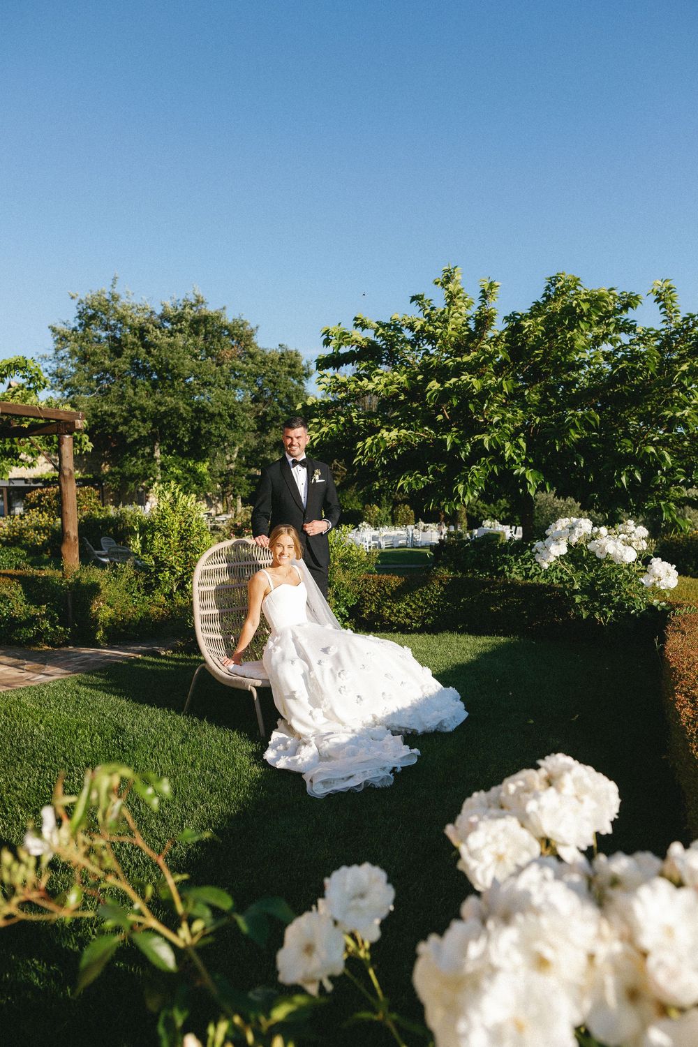 Elegant outdoor wedding scene in a lush garden setting with white flowers.