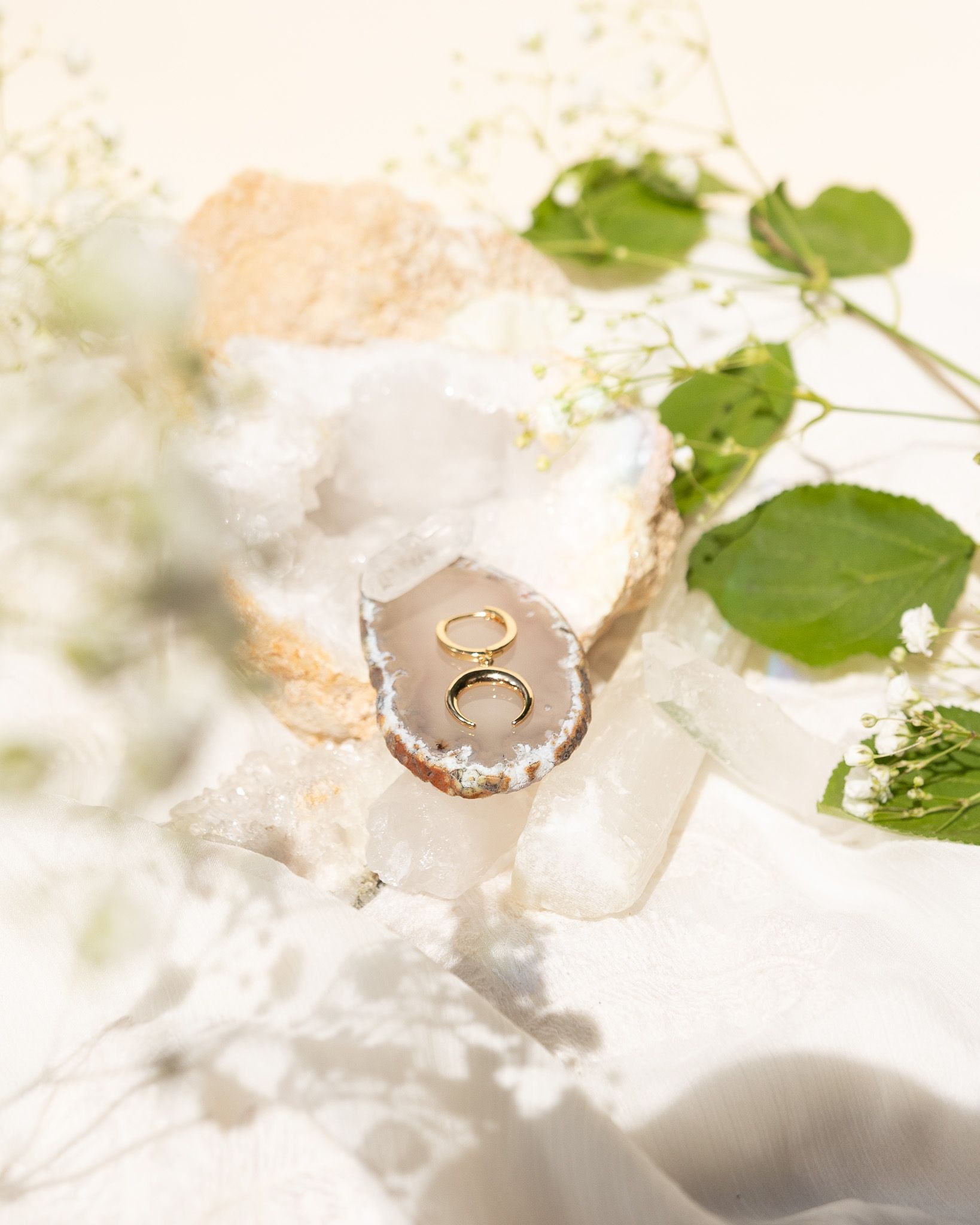Gold ring nestled in white crystal geode surrounded by delicate baby's breath flowers.