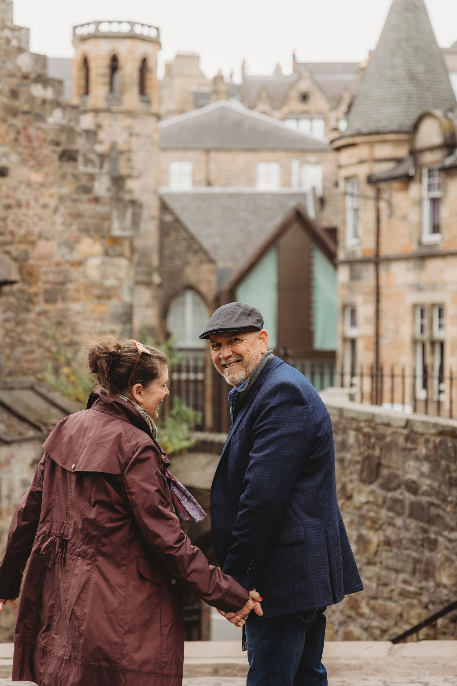 A couple enjoying a moment together in front of historic Edinburgh architecture.
