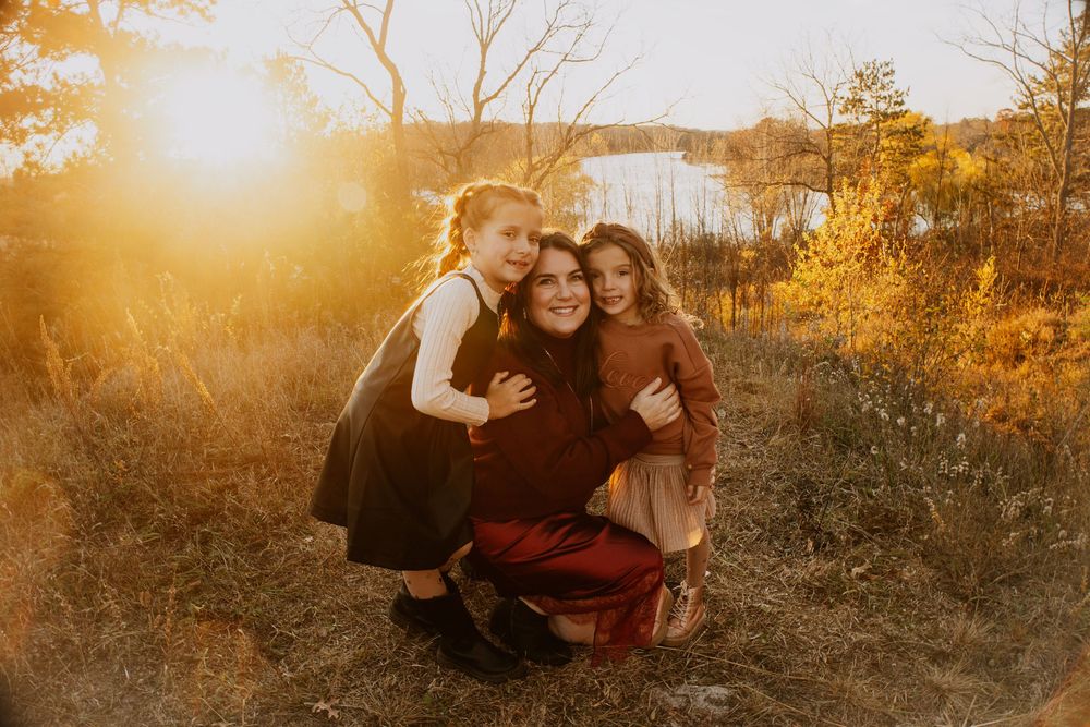 Warm sunset photoshoot on hillside with family enjoying outdoor moments together.