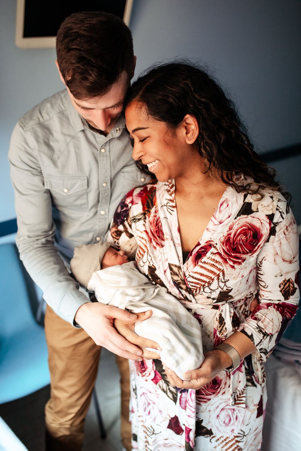 Parents sharing a special moment with their newborn baby in a hospital room.