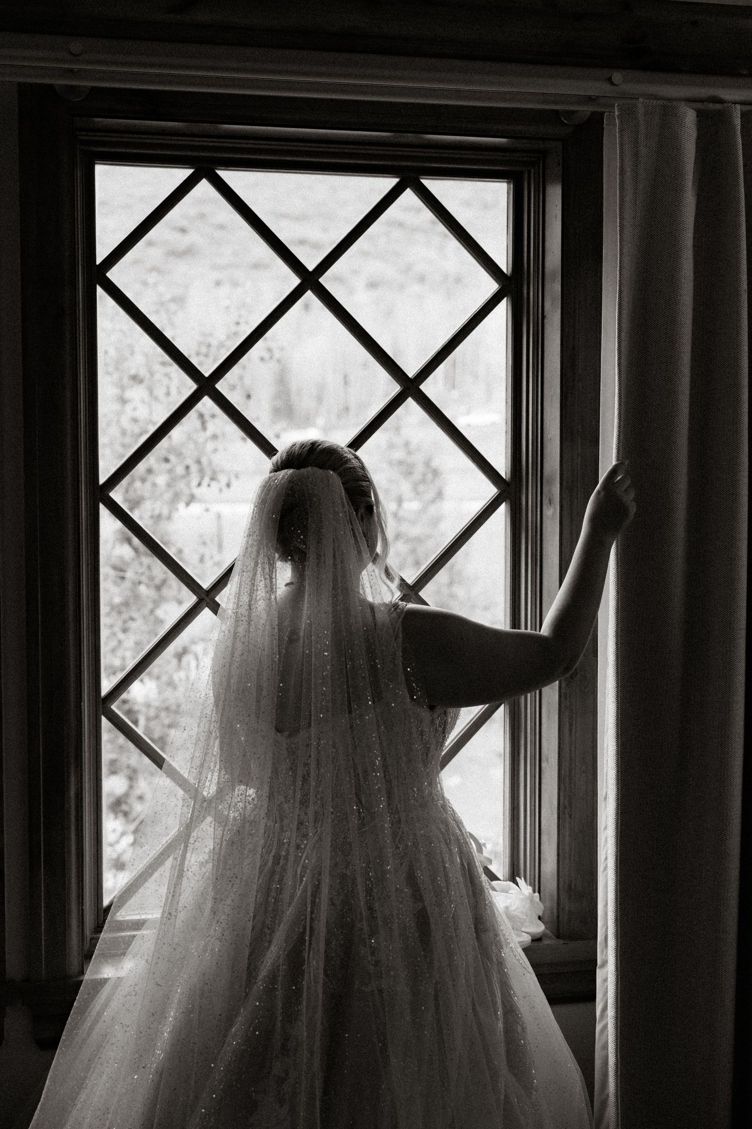 A haunting black and white series showing a ghostly figure in a veil standing by diamond-paned windows.