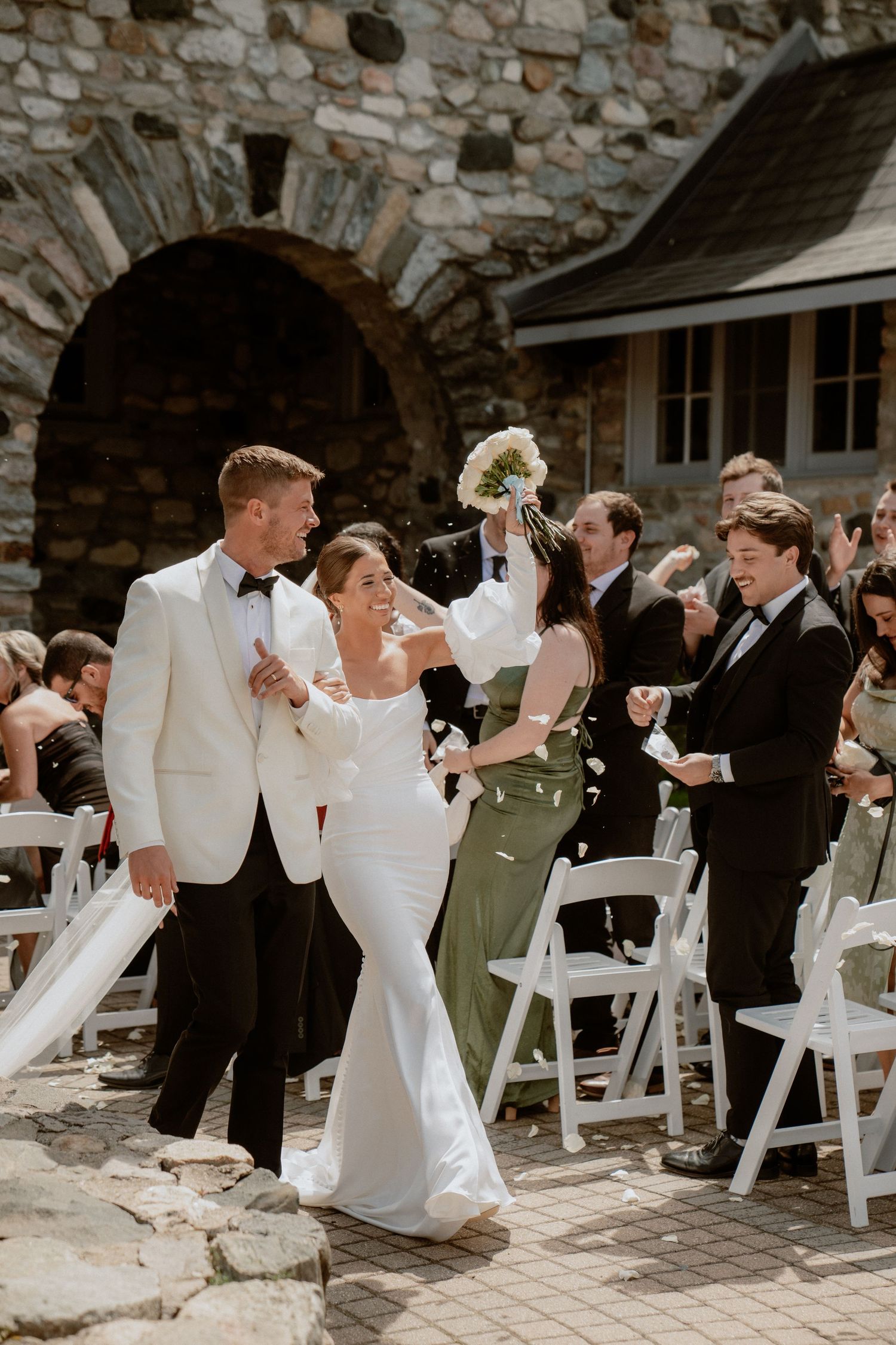 A wedding ceremony sequence showing guests enjoying the celebration in front of a rustic stone wall backdrop.