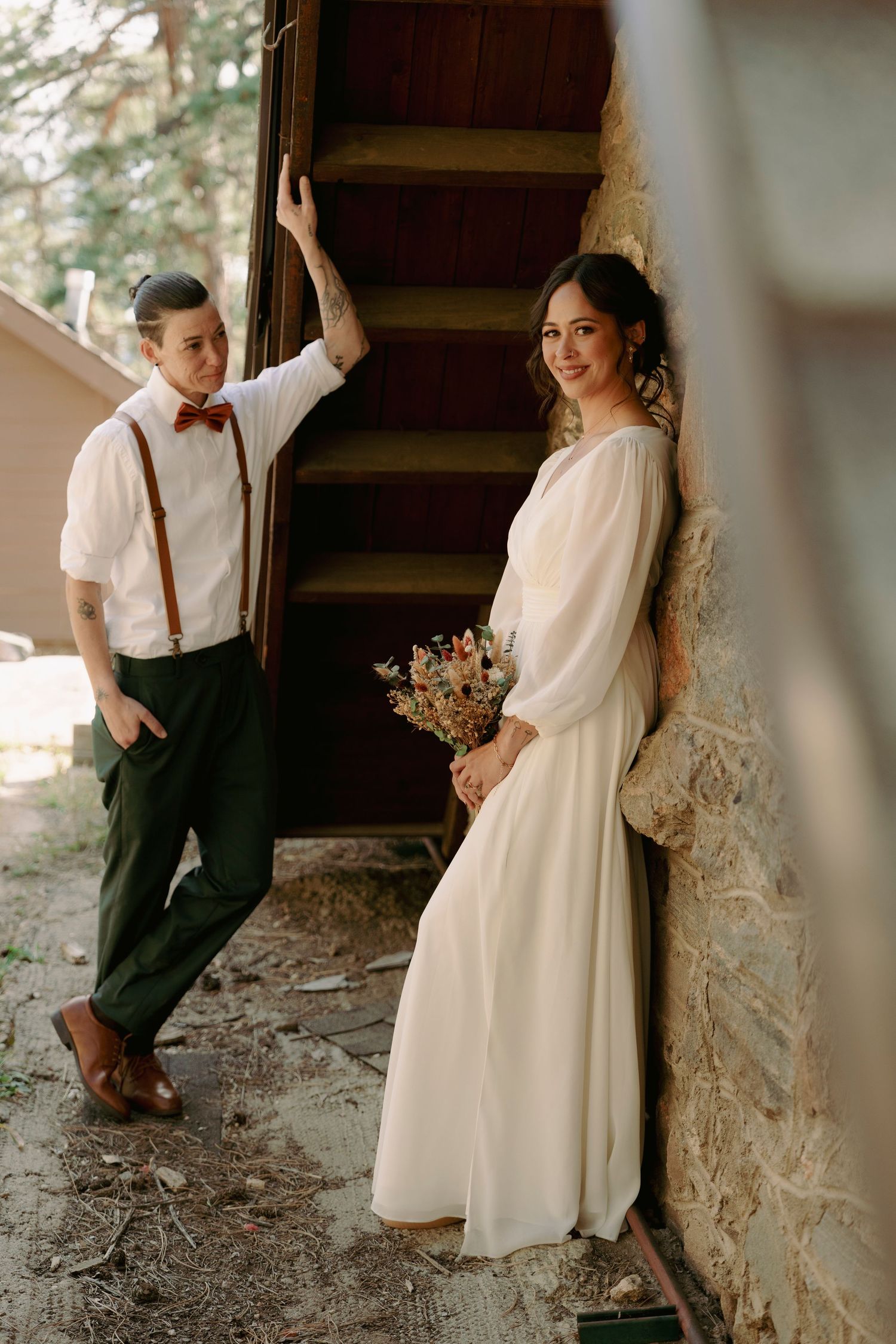 A romantic vintage-style engagement photoshoot featuring a couple posing against rustic stone walls and wooden stairs.