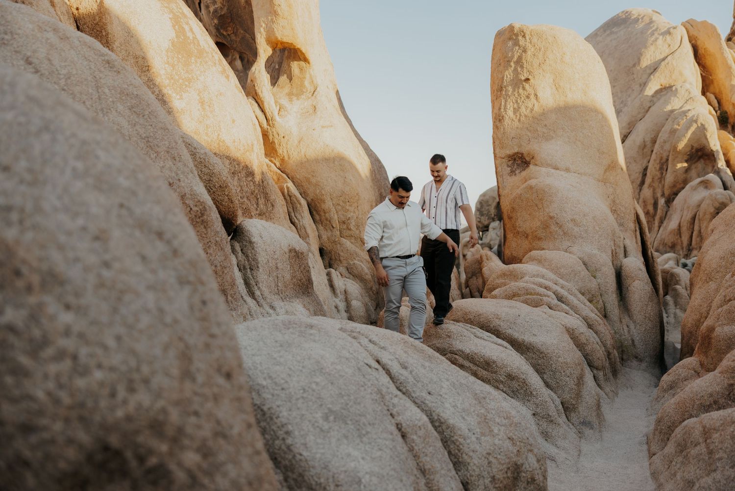Hiking through dramatic rock formations in Joshua Tree National Park during sunset.