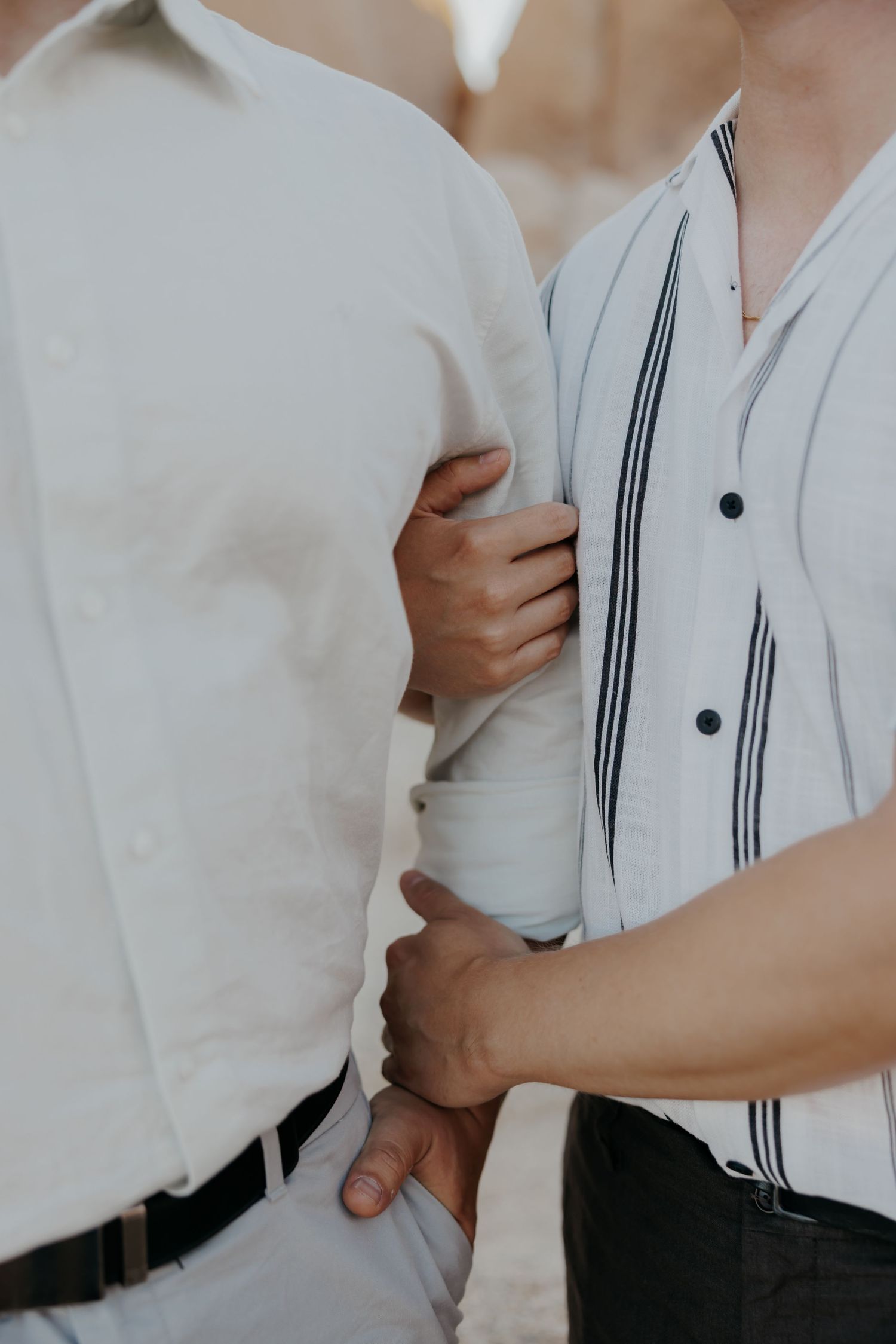 Close-up shot of two people in white shirts holding each other tenderly.