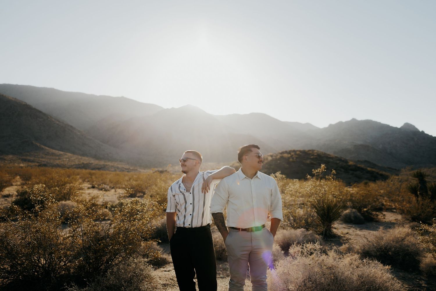 Two people walking together in desert landscape during golden hour.