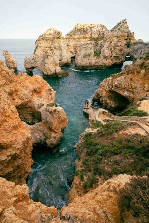 Dramatic limestone rock formations and sea arches along Portugal's Algarve coast.