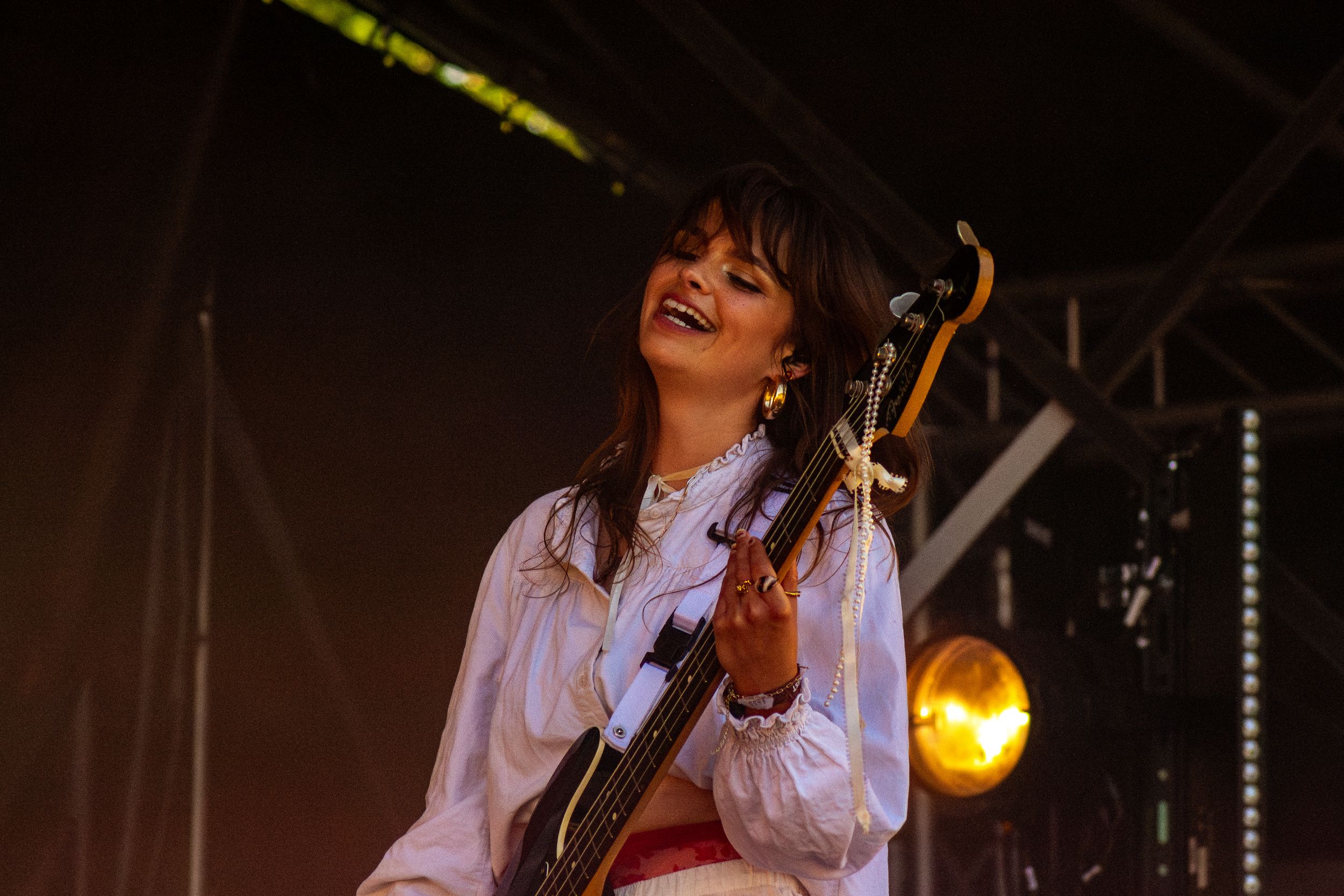 Energetic stage performance with musician playing guitar against warm stage lighting.