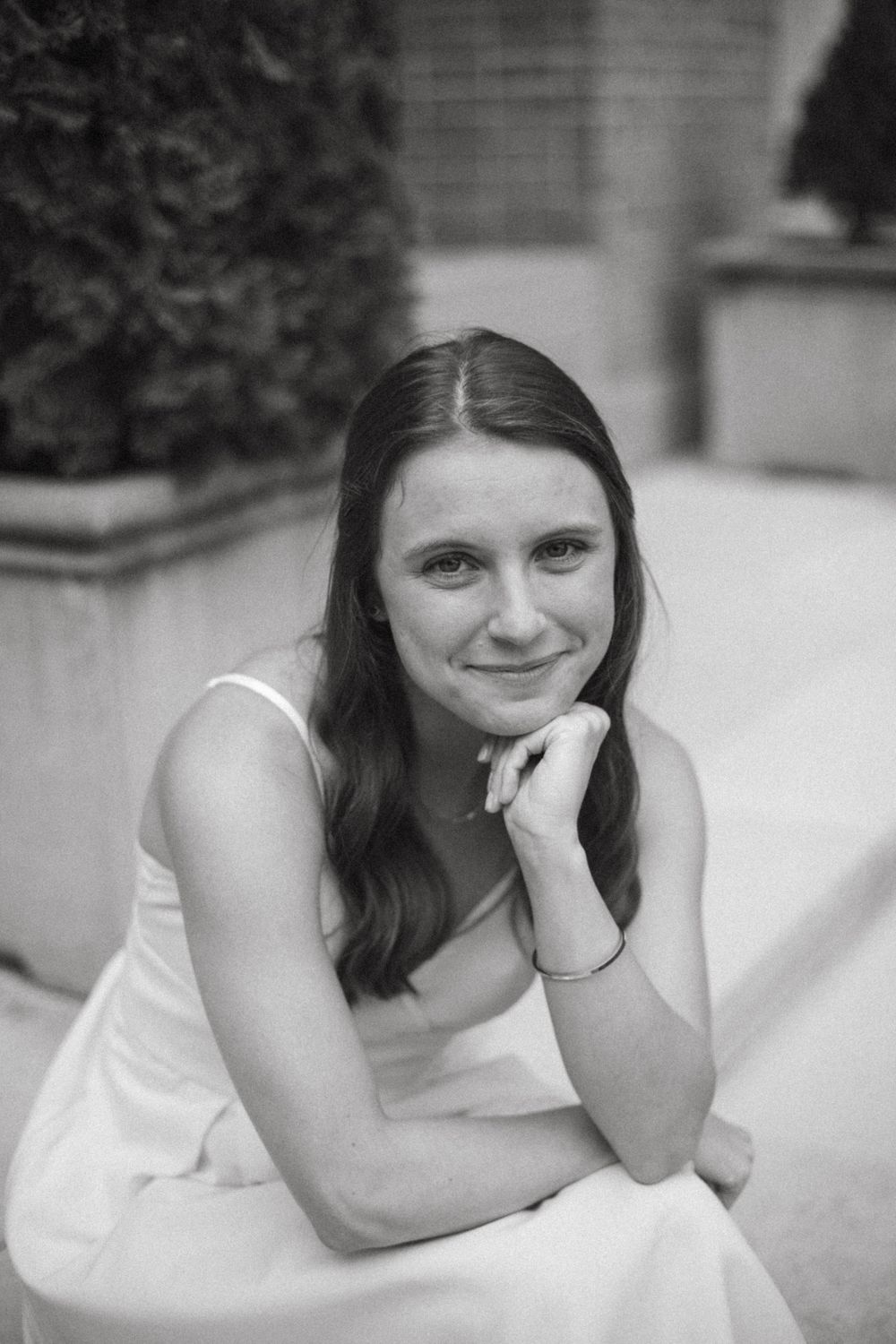 Black and white portrait series showing relaxed poses against a light background.