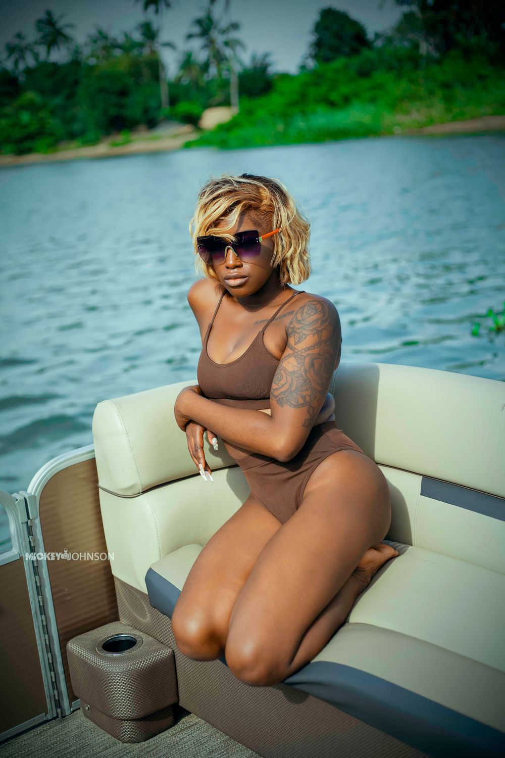 Relaxed boat photoshoot with tropical scenery and water in background.