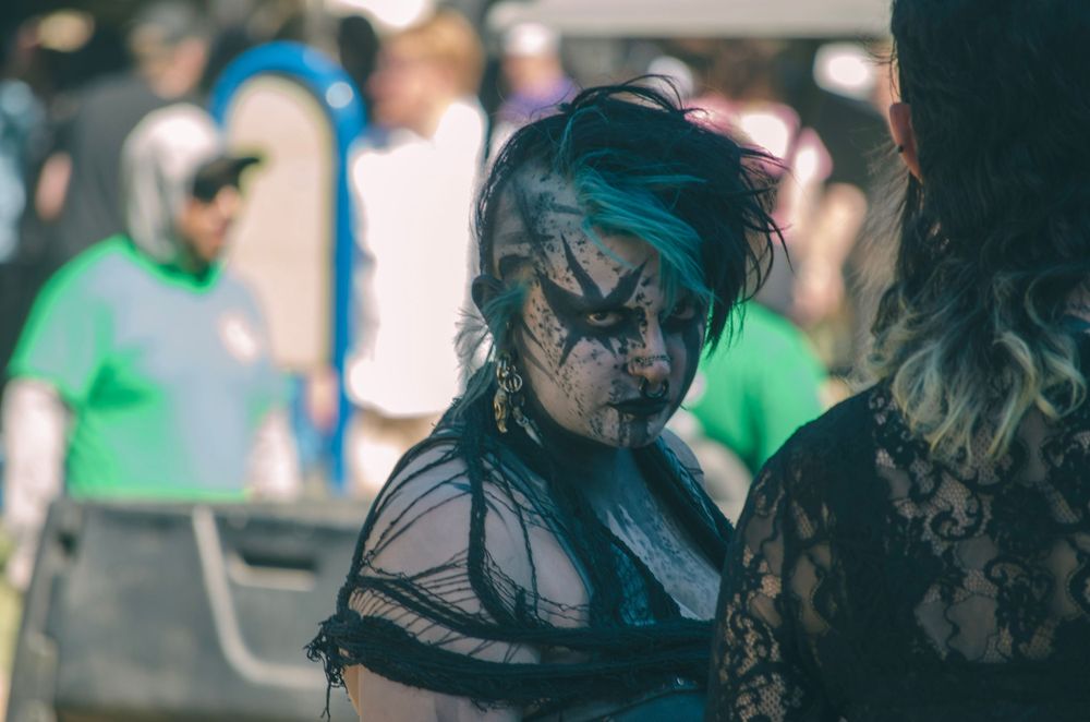 Person in elaborate costume and face paint at an outdoor event.