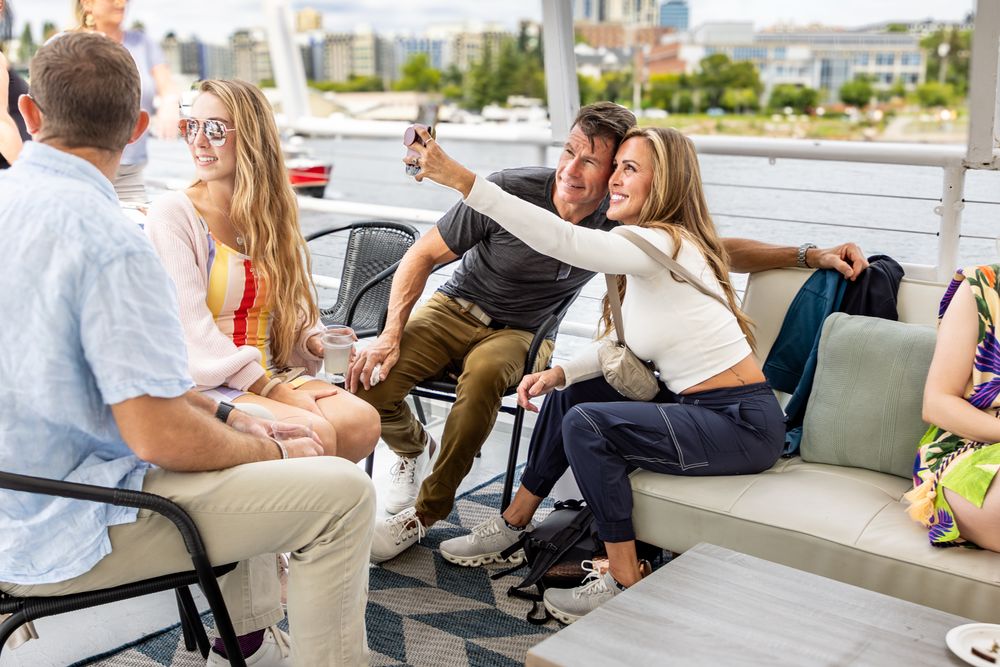 Group of people having a business meeting in a modern office setting with glass walls and natural lighting.