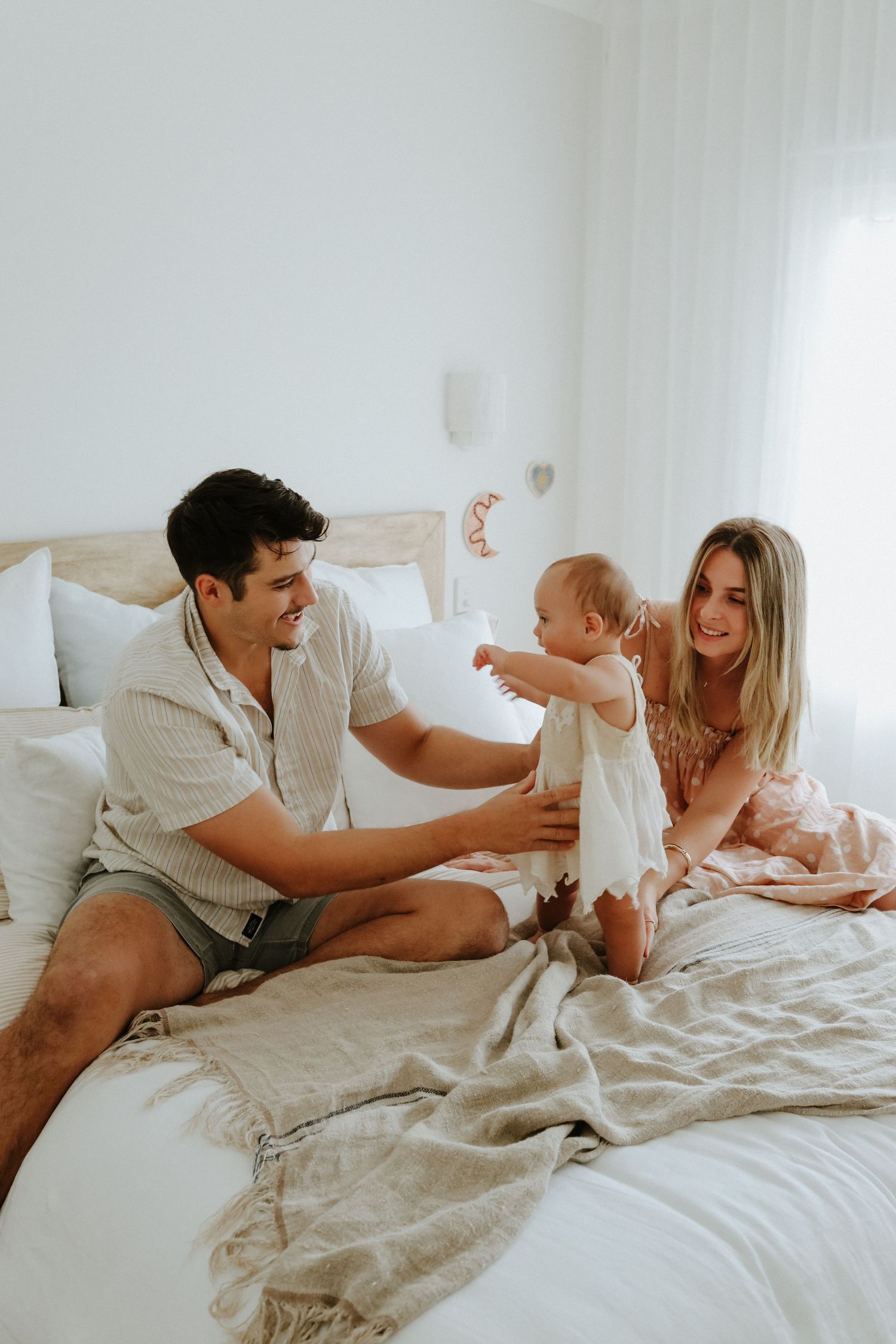 A joyful morning scene of family bonding on a cozy white bed.
