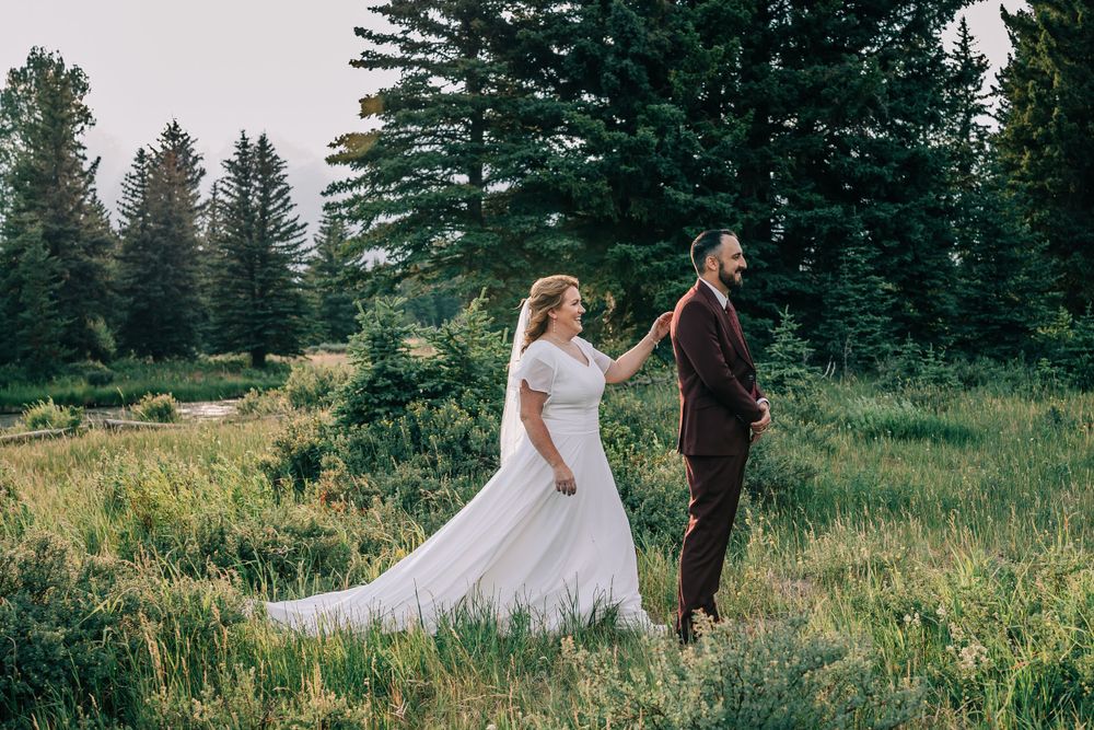 Bride touching groom's should in anticipation of his first look at her