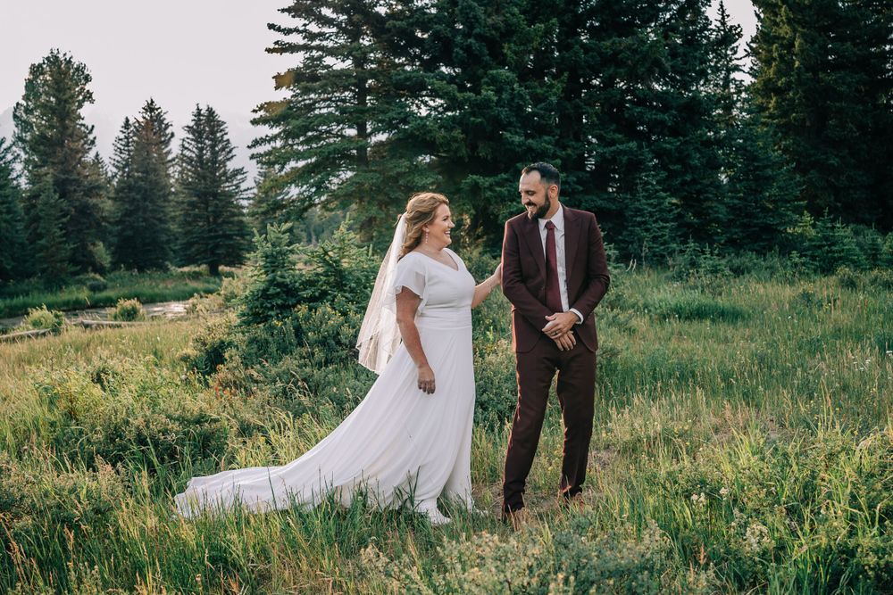 Groom smiling at the bride during first look in the rugged Teton mountains
