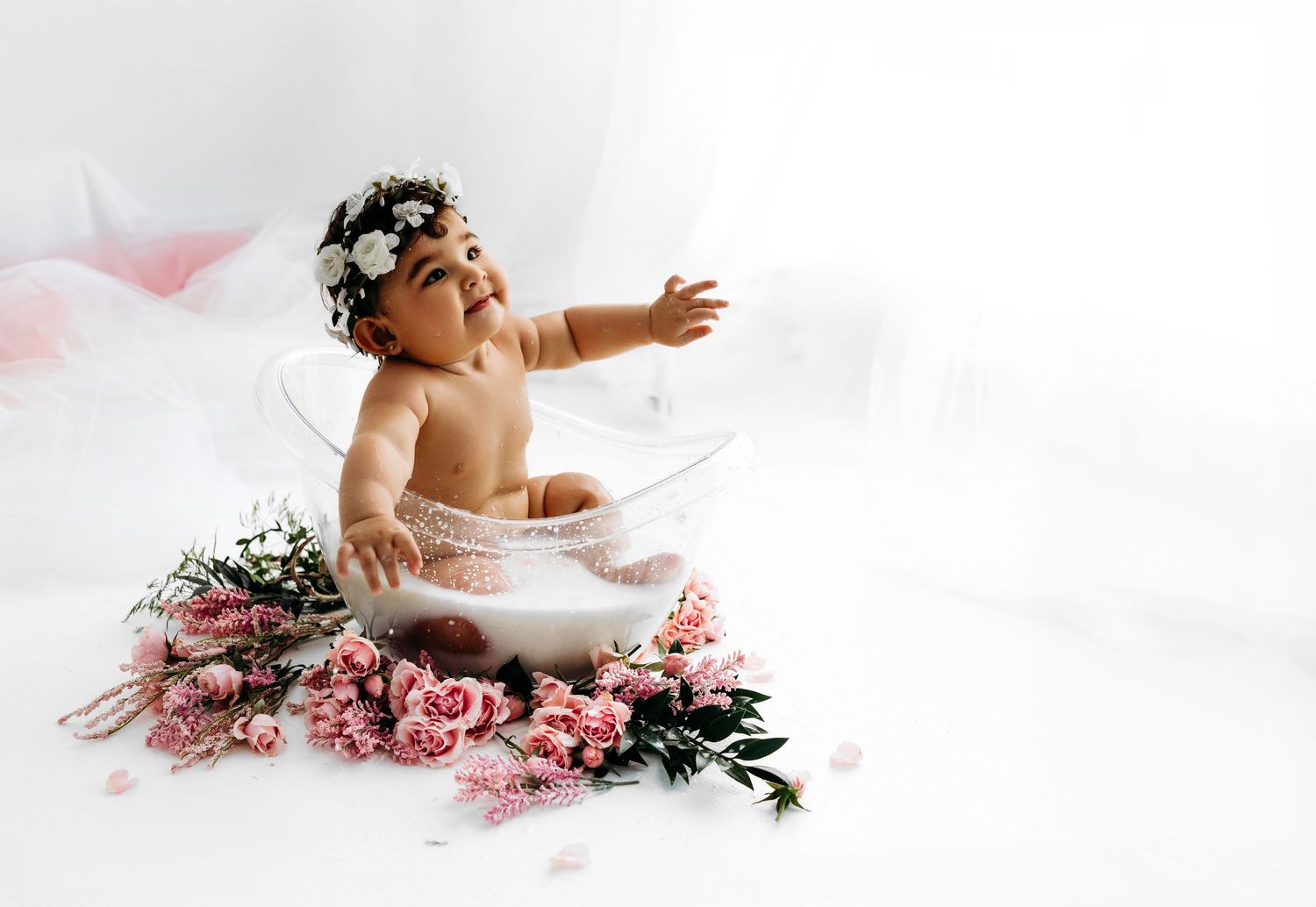 Baby in white tutu sits among pink flowers wearing floral crown against white backdrop.
Rashinphotography-Nova photographer- DMV DC