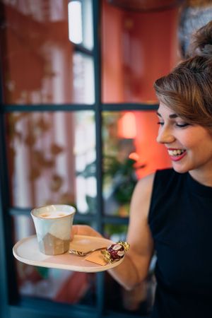 Spontane opname van iemand die koffie en gebak serveert in een café met oranje muren.