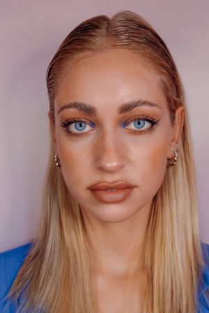 Close-up beautyportret met professionele make-up en strak blond haar.