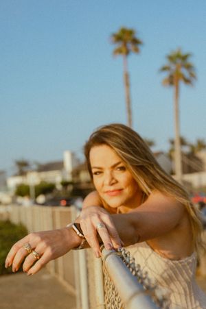 Casual beachwear portrait with palm trees in background during sunset.