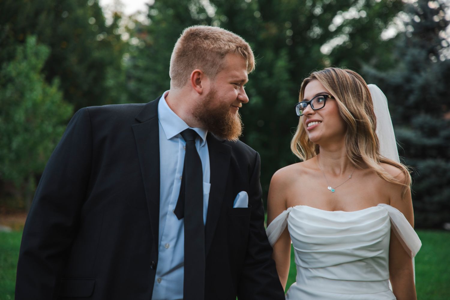 Romantic outdoor wedding portraits in garden setting during golden hour.