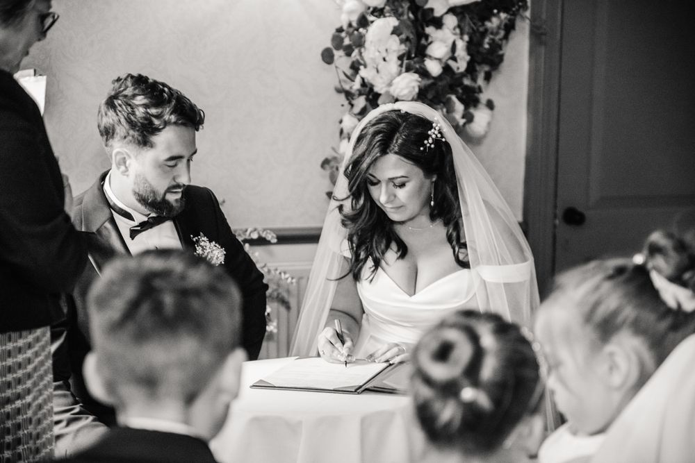 Bride and groom are signing the wedding register at Hotel Du Vin in Winchester