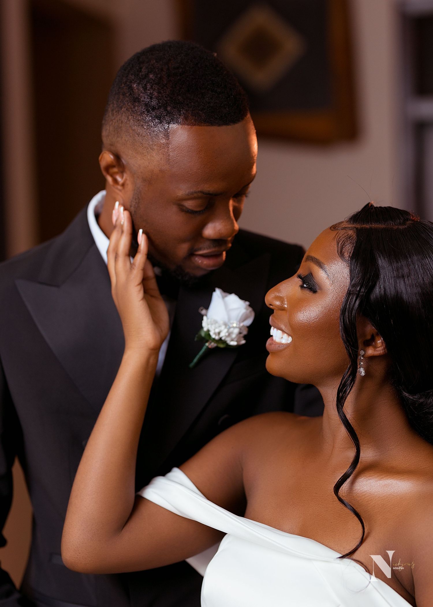 A romantic wedding portrait of a couple sharing an intimate moment in formal attire.