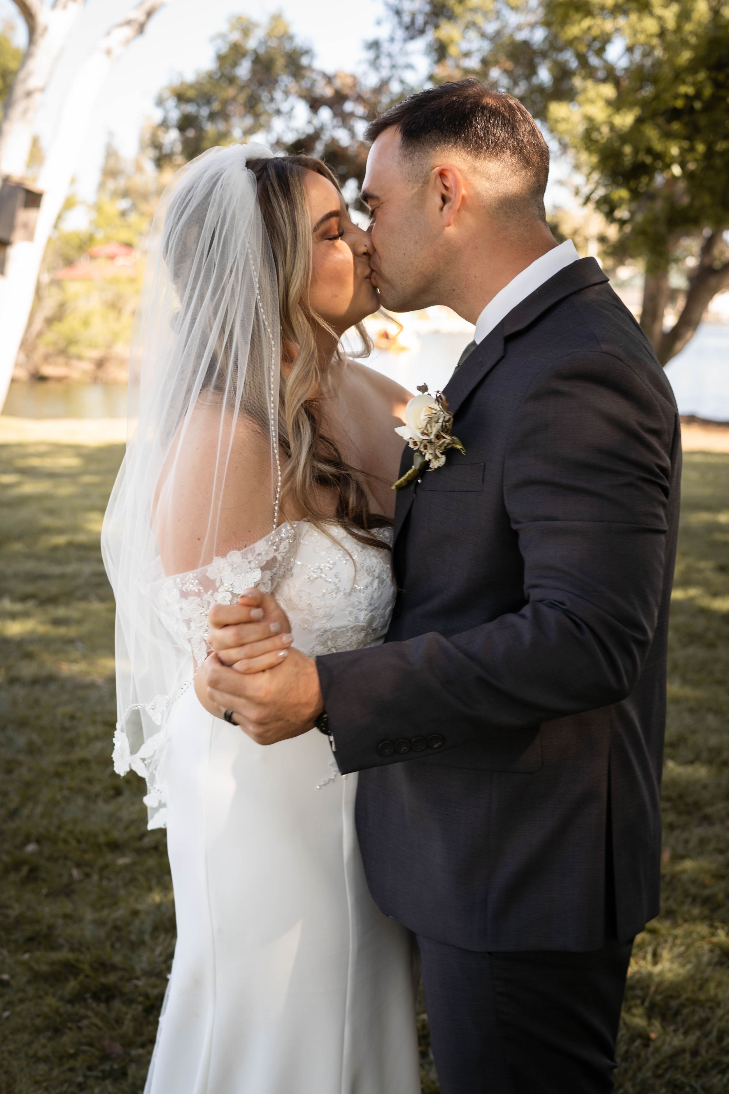 An intimate wedding portrait capturing a tender moment between newlyweds outdoors.