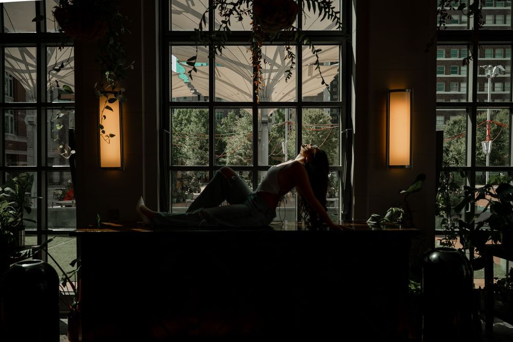 Editorial and artistic Fort Worth greenhouse senior photoshoot surrounded with greenery and soft mood lighting