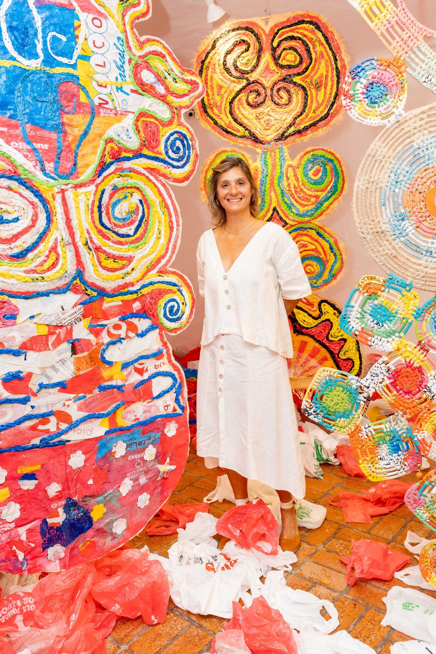 Whimsical art gallery installation with swirling colorful hanging plastic scultptures and decorative elements.