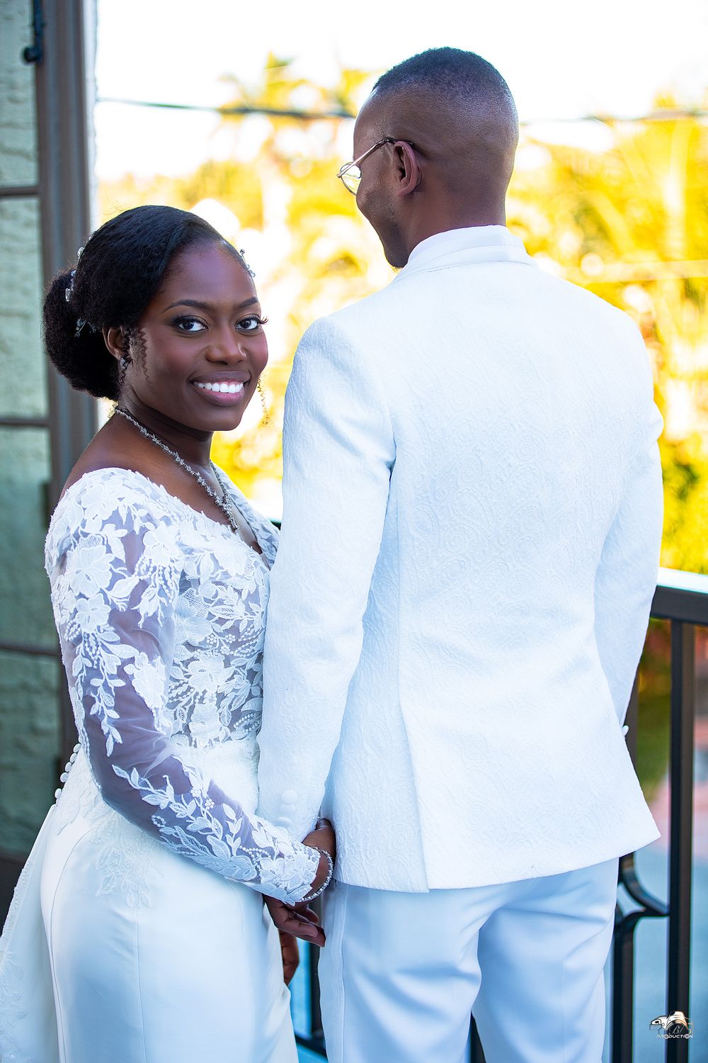 Elegant outdoor wedding portrait with tropical palm trees in background.