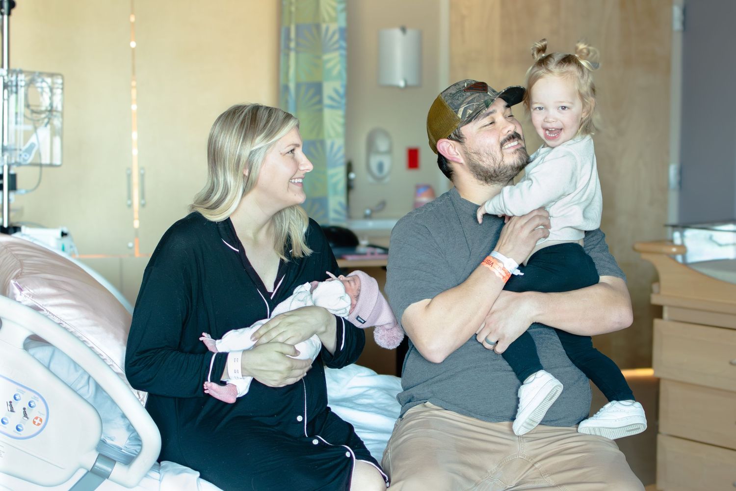 Family sharing joyful moments together in a hospital room.