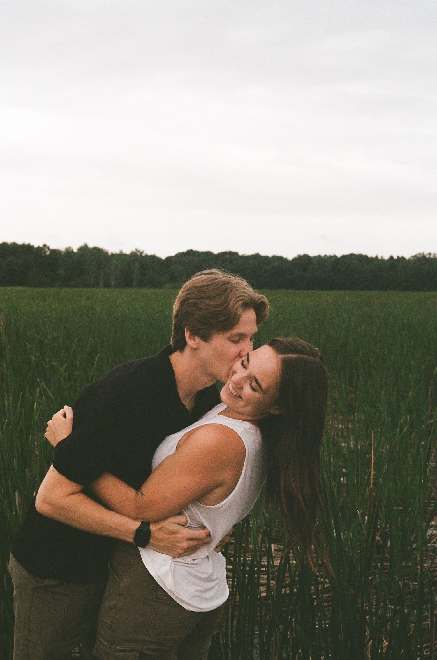A couple session on film of the boyfriend kissing the girl on the cheek in Coon Rapids Minnesota
