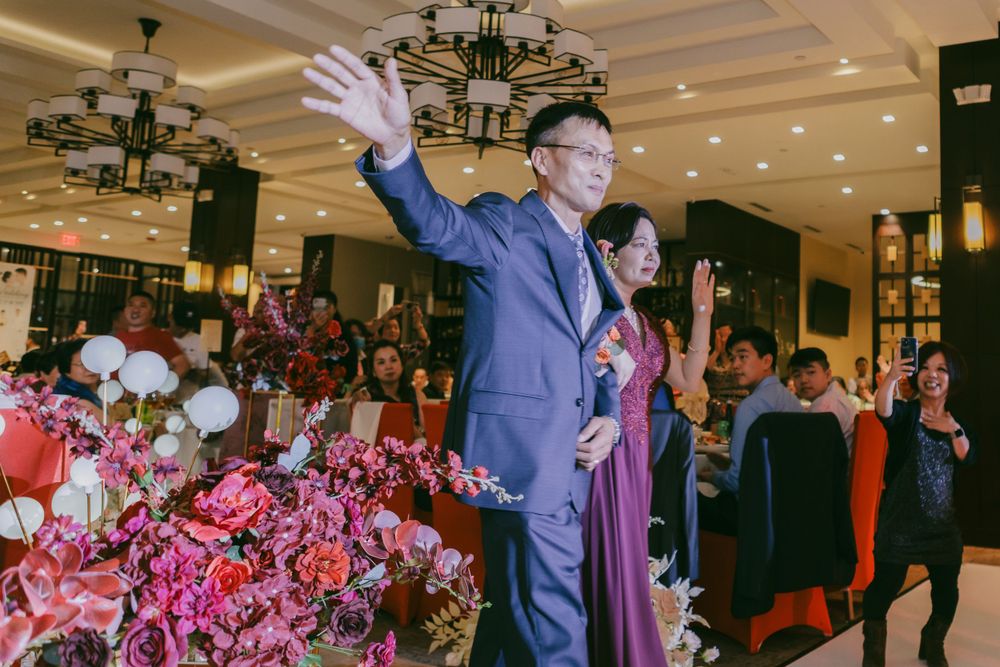 Wedding celebration in a grand ballroom with festive lighting and decorative balloons.