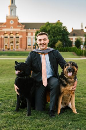 Caleb Helsley poses with his two dogs to celebrate his Oklahoma State University College of Veterinary Medicine graduation.