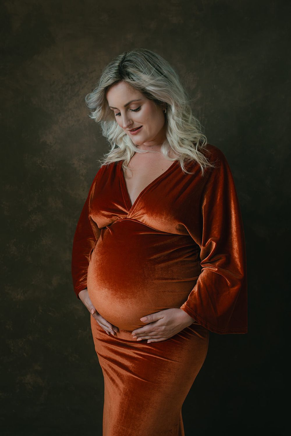 portret van zwangere dame in oranje fluwelen jurk. Klassiek portret