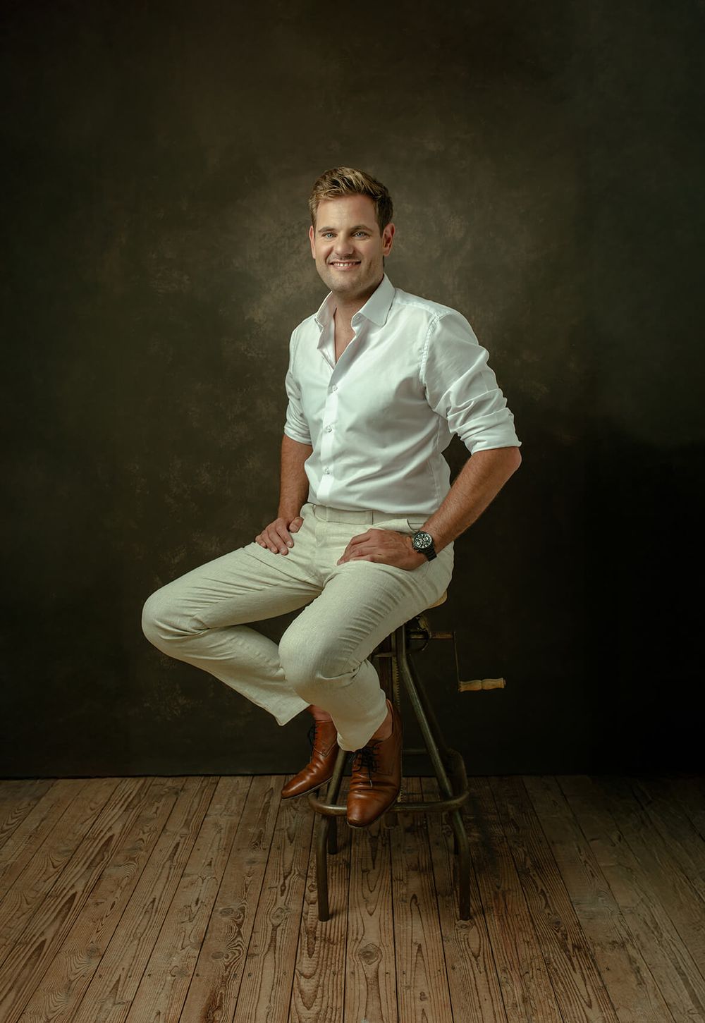 Tijdloos portret van een meneer zittend op een kruk. Studio portret