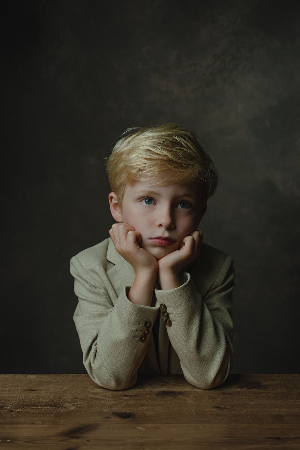 klassiek portret van jongetje aan tafel met rembrandtlicht